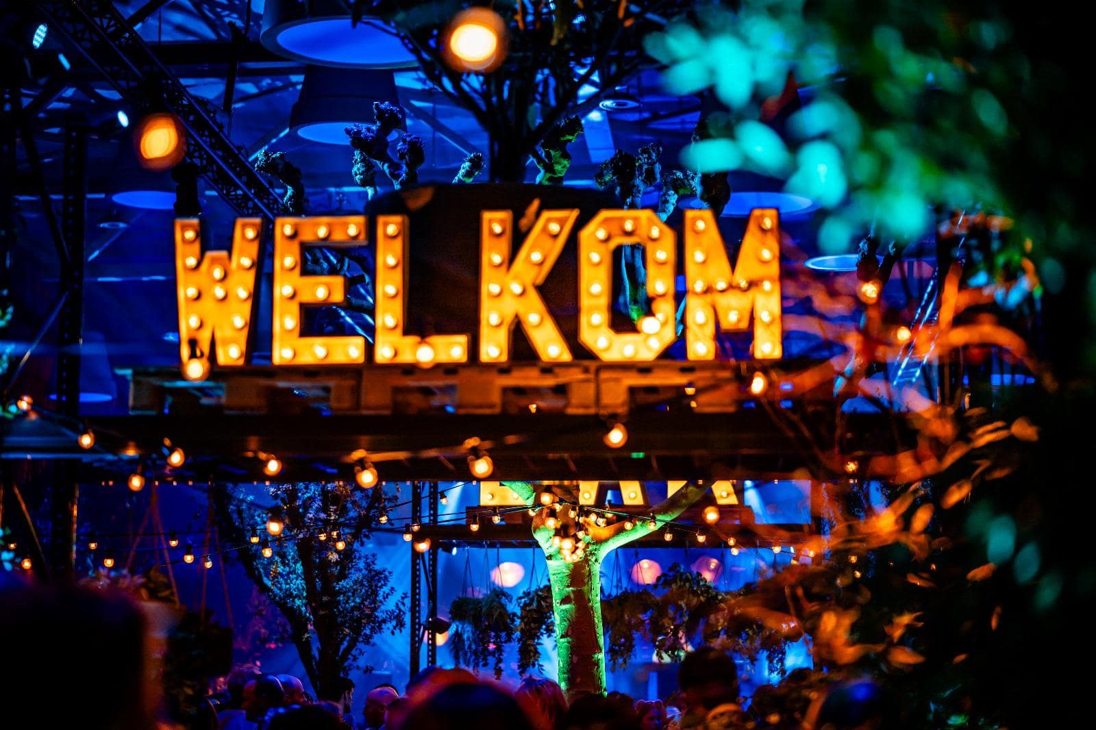 Verlicht welkomstbord in een sfeervolle evenementenruimte